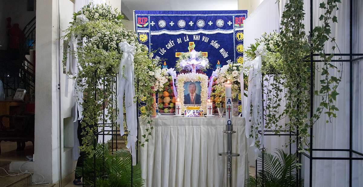 Bàn thờ trong đám tang có đặt di ảnh người mất và bát hương, một bình hoa huệ trắng, cây thánh giá, trước nhà có treo cờ báo tang.