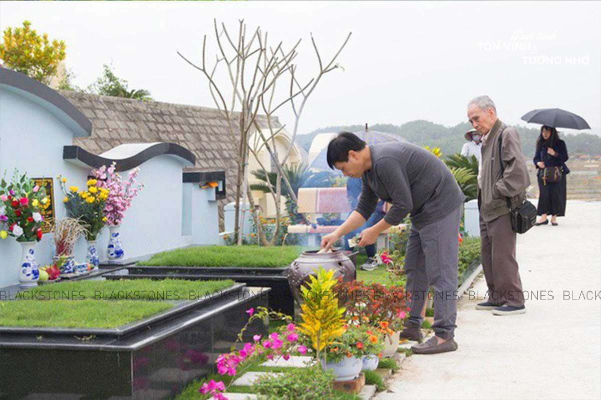 Gia đình dọn dẹp mộ phần và thắp hương vào dịp Thanh Minh